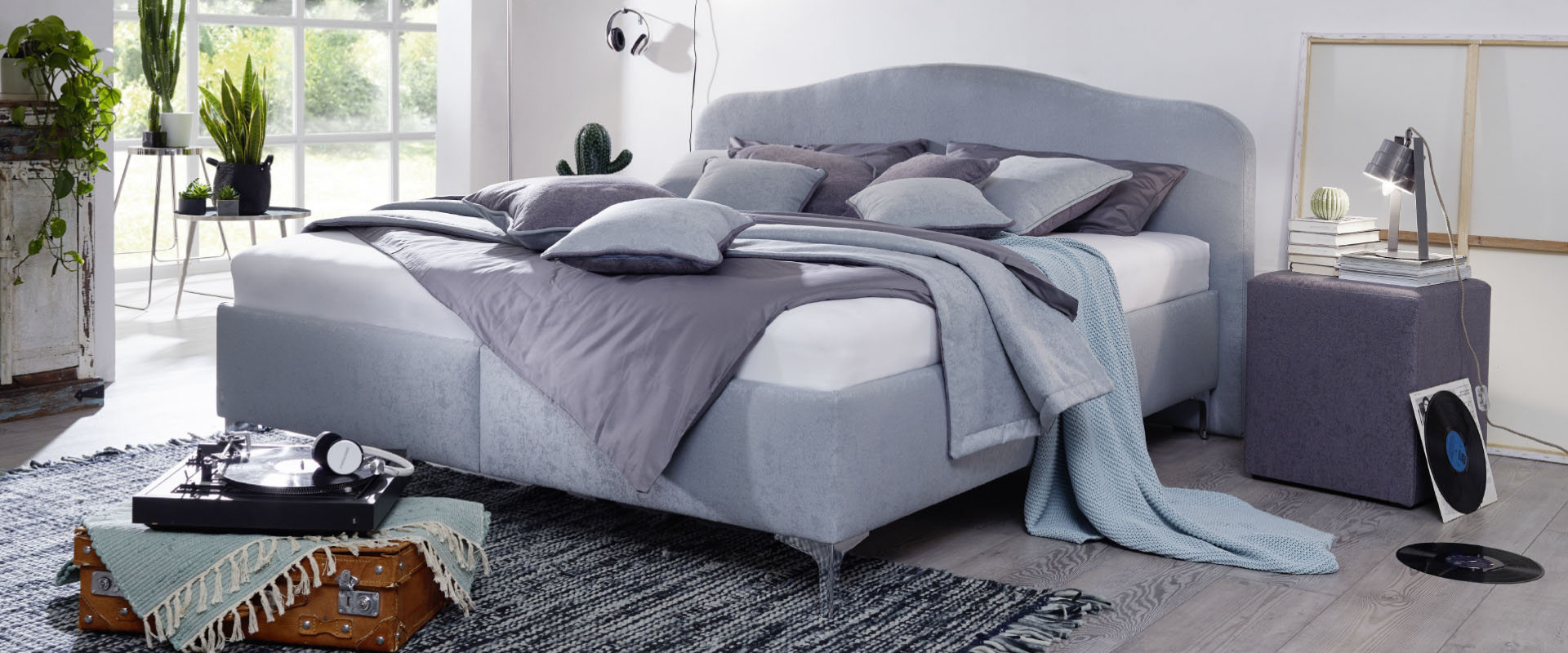 Schlafzimmer mit grauem Bett