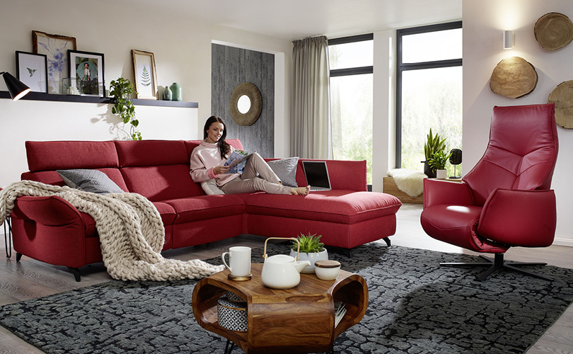 Frau auf rotem Sofa sitzend und lesend